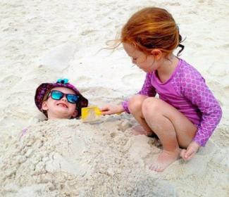 孩子玩沙子在海湾海岸的海滩