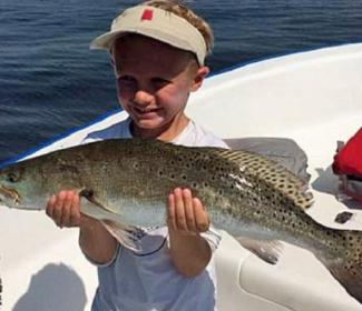 young boy holding speckled trout