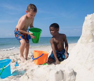 孩子们在美国海湾海岸建造沙堡