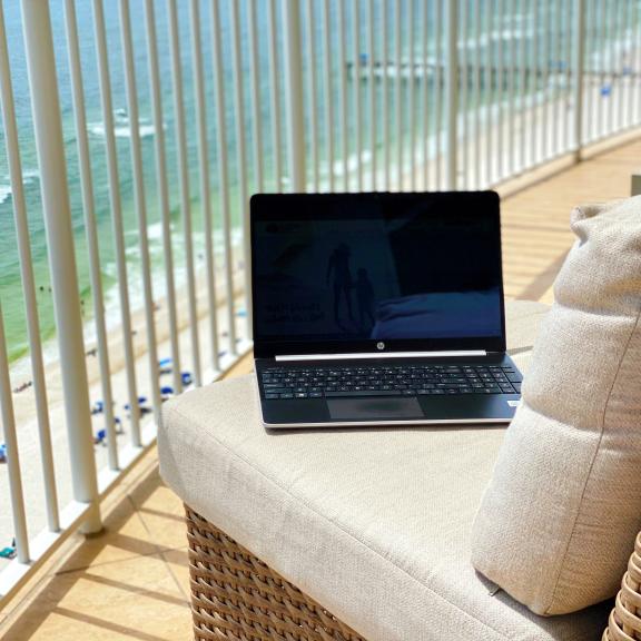笔记本电脑在海湾海岸的阳台上